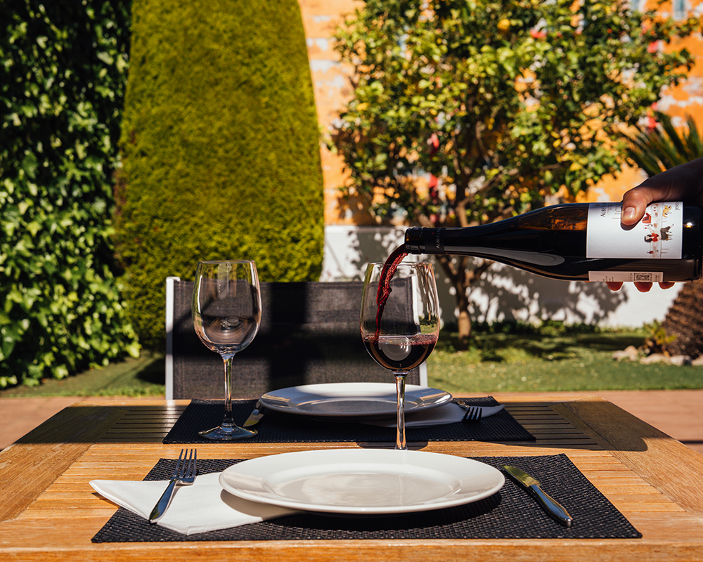 Una taula a la terrassa de Clos d’en Pep amb vi servit a la copa